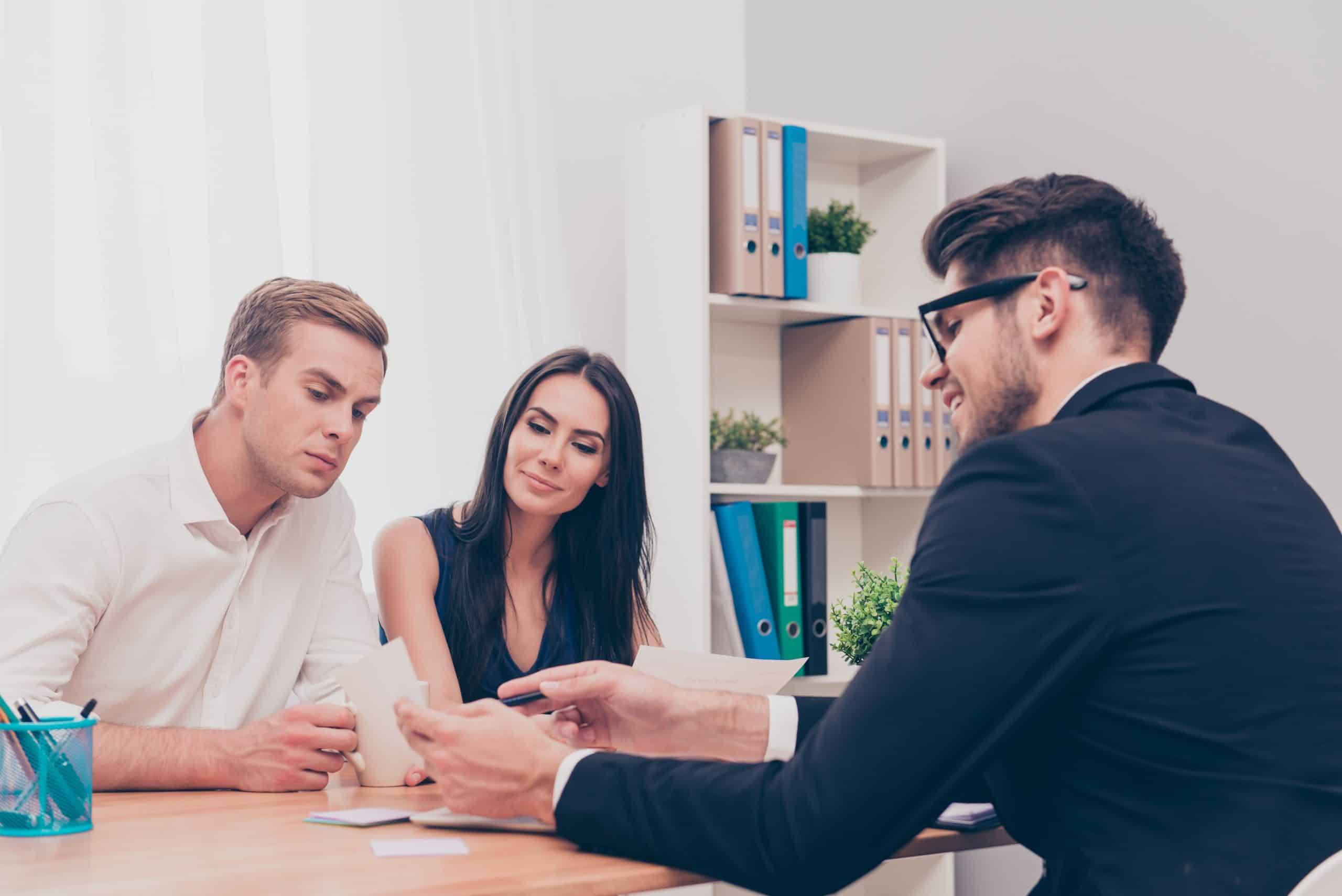 Happy young couple on consultation in real eatate agent
